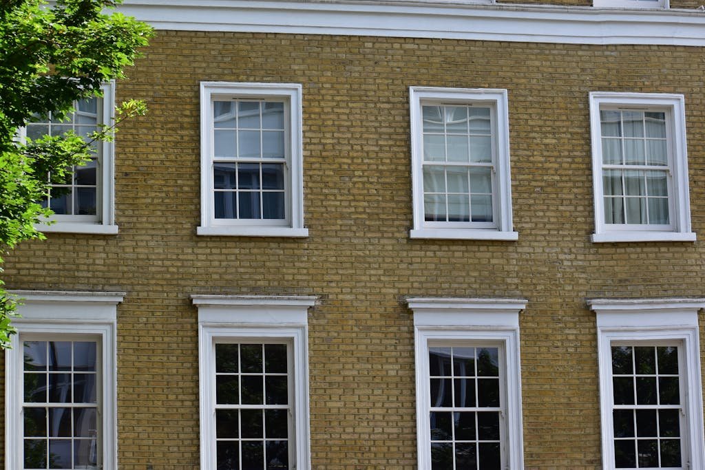 Detailed view of a vintage brick building facade with white framed windows in London.